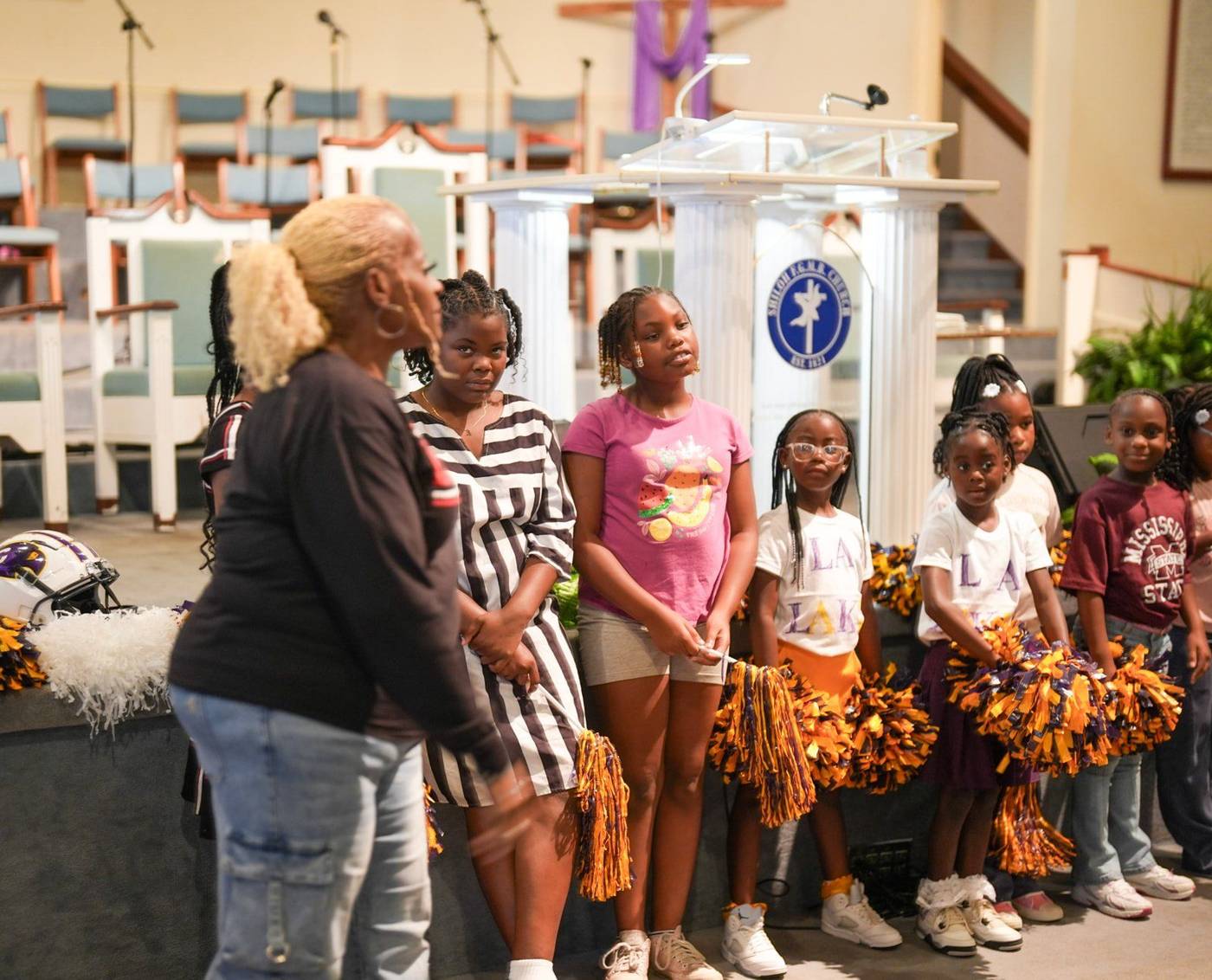 Girls with pom-poms in front of the pulpit during a youth celebration