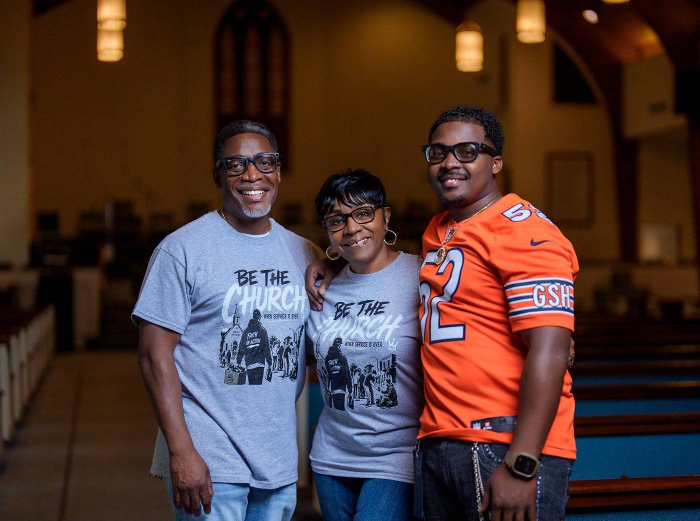 Pastor Ty Harris with two members in Be the Church shirts in the sanctuary