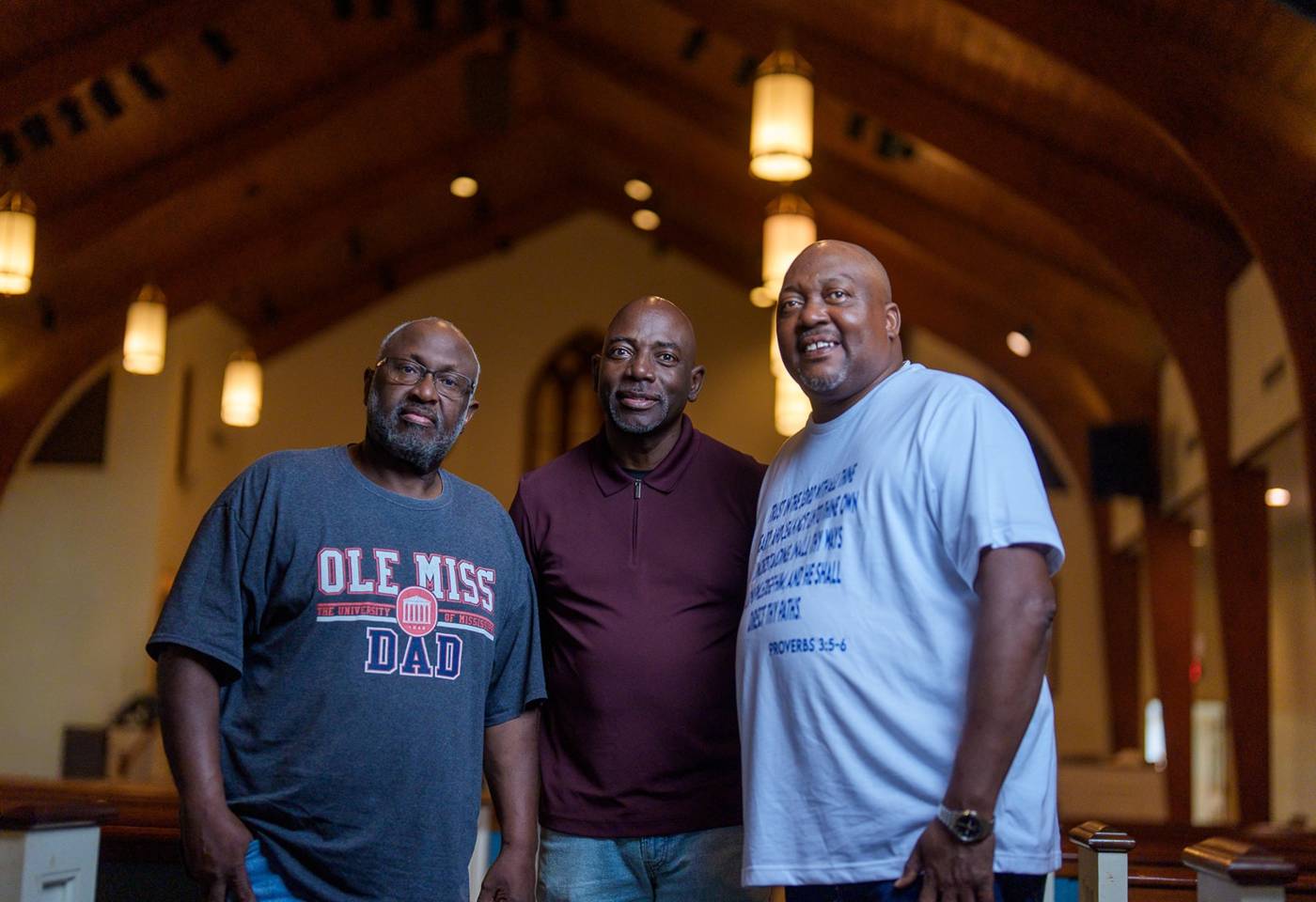 Three men of Shiloh standing together in the sanctuary under the wood-beamed ceiling